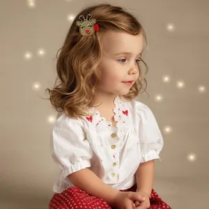 Detailed view of child wearing a gold glitter reindeer hair clip for Christmas outfit
