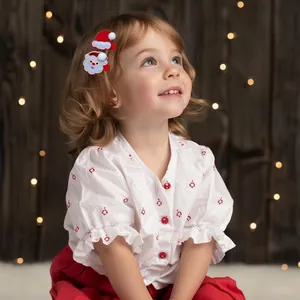 Detail of children's Christmas hair clips featuring Santa hat and face on a girl