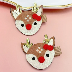 Détail de barrettes renne avec bois en tissu, nœuds rouges et nez en peluche pour enfants