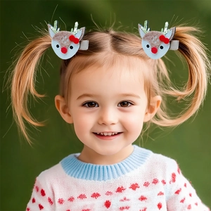 Détail de jolies pinces à cheveux renne de Noël avec bois scintillants et nœud rouge