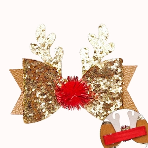 Détail de pince à cheveux bois de renne pailleté avec nœud, pompon et clip crocodile