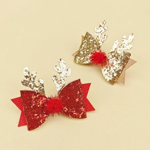 Détail de pinces à cheveux bois de renne de Noël avec nœuds pailletés et pompons