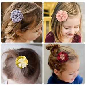 Détail montrant plusieurs couleurs de barrettes fleurs en tissu faites à la main