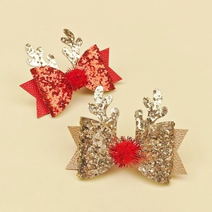 Détail de pinces à cheveux bois de renne de Noël avec nœuds pailletés et pompons