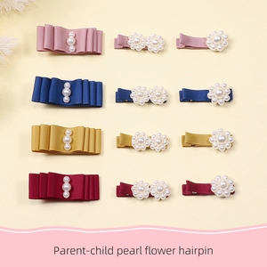 Flat lay of handmade fabric bow hairpins and pearl flower clips in four elegant colors