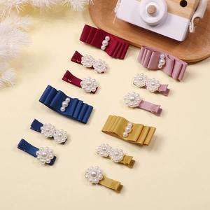 Detailed set of 12 handmade ribbon bow hair clips with pearls for girls in four vibrant colors