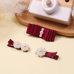 Detailed view of handmade burgundy ribbon hair clip with elegant pearls for girls
