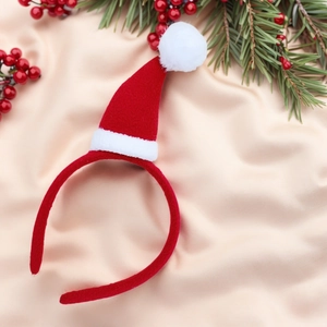Détail d'un serre-tête avec mini bonnet de Noël en feutre rouge et pompon blanc