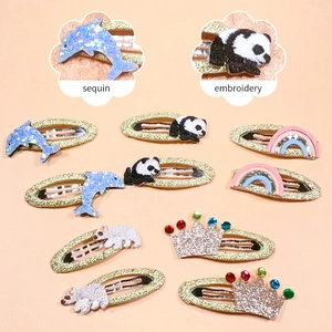 Detail view of sequin and embroidery textures on animal-themed children's hair clips