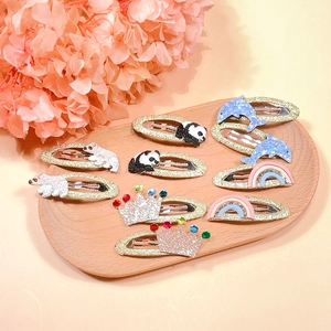 Detail view of 10-piece embroidered animal hair clips with rainbow and crown motifs