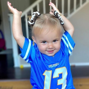 Détail du maillot de football bleu Chargers et du nœud à cheveux rugby à paillettes assorti