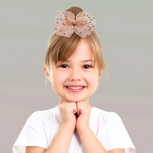 Detail einer rosa Pailletten-Schleife mit Punkten für Kinder, am Haar getragen