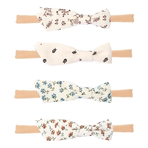 Close-up of four floral print baby headbands with elastic nylon bands in various colors