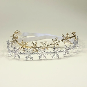 Detail view of elastic headbands with gold and silver snowflake cutouts for infants