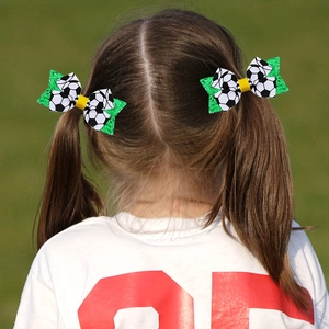 Détail d'un enfant portant des nœuds à cheveux thème football avec paillettes vertes