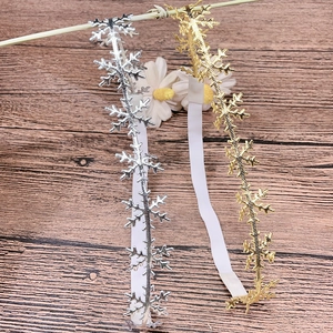 Detail of elastic baby headband with gold and silver snowflake metallic patterns