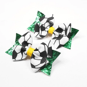 Détail du nœud à cheveux foot avec étoile verte pailletée et ruban à motif football