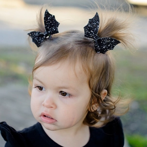 Sparkly black bat wing hair clips for girls worn on pigtails for Halloween costumes