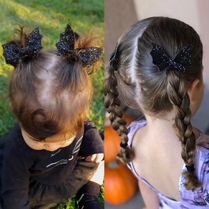 Close-up of black sequined bat wing hair clips for Halloween hair styling for kids