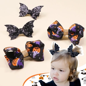 Detail of Halloween hair clips with bat wings and pumpkin bows on light background