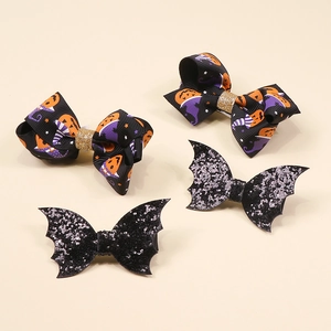 Set of four Halloween hair clips featuring glittery bats and pumpkin ribbon bows