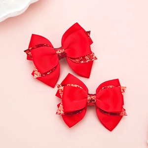 Vue détaillée de pinces à cheveux rouges à paillettes pour filles sur fond rose