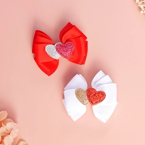 Detailaufnahme von Schleifen mit Glitzerherzen auf handgefertigten Kinder-Haarspangen
