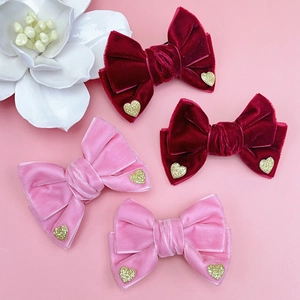 Detalle de pinzas para el cabello de terciopelo con corazones dorados en rojo y rosa