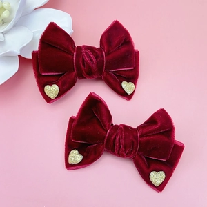 Detalle de pinzas para el cabello en terciopelo rojo oscuro con corazones dorados