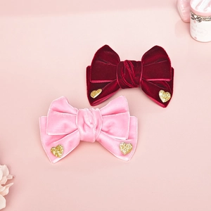 Detalle de lazos para el pelo en terciopelo burdeos y rosa con corazones dorados de brillo