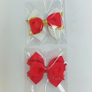 Détail de nœuds à cheveux scintillants rouges et blancs avec ruban gros-grain