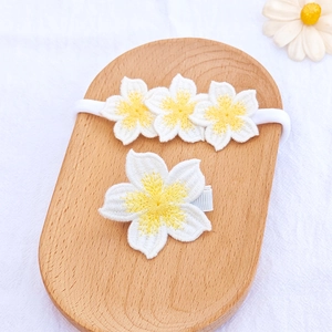 Floral baby headband and hair clip set with white embroidered flowers on wooden tray
