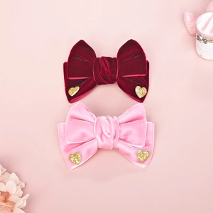 Detalle de lazos para el pelo en terciopelo rojo y rosa con corazones brillantes