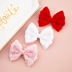 Detailed view of handmade lace bow headbands with floral design for infants
