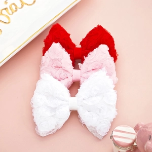Detailed close-up of lace mesh bow hair clips with textured rose flower patterns