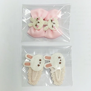 Détail de barrettes lapin en tricot rose et nœuds en dentelle pour petites filles