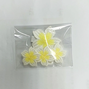 Detail of handmade crochet plumeria flower clips and headbands in packaging