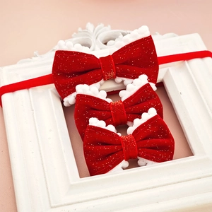 Detailed view of red velvet hair bows with white fur pom-poms in three different sizes