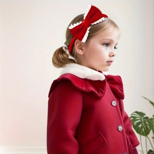 Close-up of kids red velvet headband with a large glitter bow and white lace trim detail
