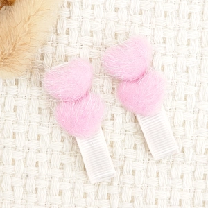 Detailansicht der flauschigen Herz-Haarspangen in Pink und Weiß mit Samtstruktur