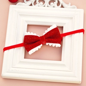 Close-up of velvet red New Year hair band with white pompom trim and gold glitter finish