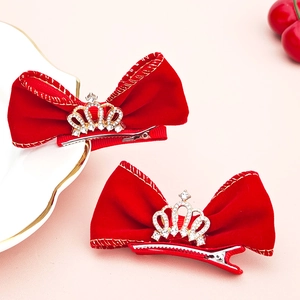 Détail d'un nœud en velours rouge avec couronne en strass et liseré doré élégant