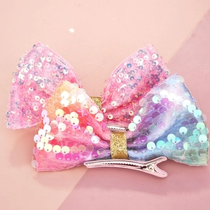 Dettaglio dei fermagli per capelli a fiocco con paillettes per bambine e clip a becco d'anatra rosa
