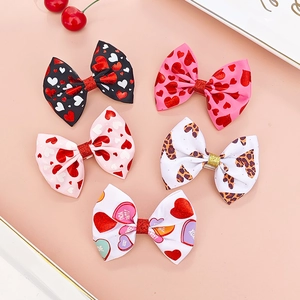 Close-up of five colorful heart bow hair clips made of textured grosgrain ribbon