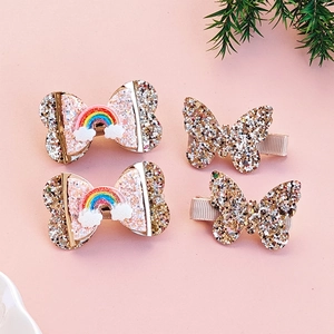 Golden butterfly and rainbow bow hair clip set for girls on a pink background