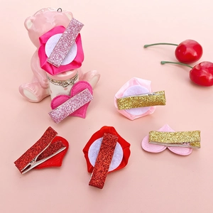 Glittery heart and rose fabric hair clips for girls on a pink decorative background