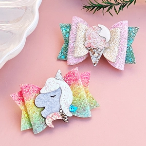 Detailed view of glitter unicorn and ice cream hair clips with shimmering texture