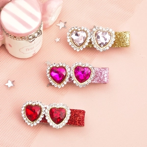 Three glittering heart-shaped gemstone hair clips for girls in pink and red shades