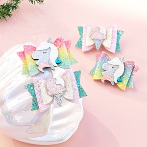 Detail of girls glitter unicorn and ice cream hair bows set on soft pink background