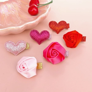 Detail of pink rose flowers and glitter heart hair clips set on shell tray decor